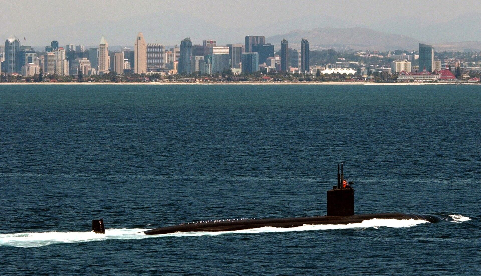 A U.S. Navy fast-attack submarine on the surface off San Diego with the downtown skyline behind it
